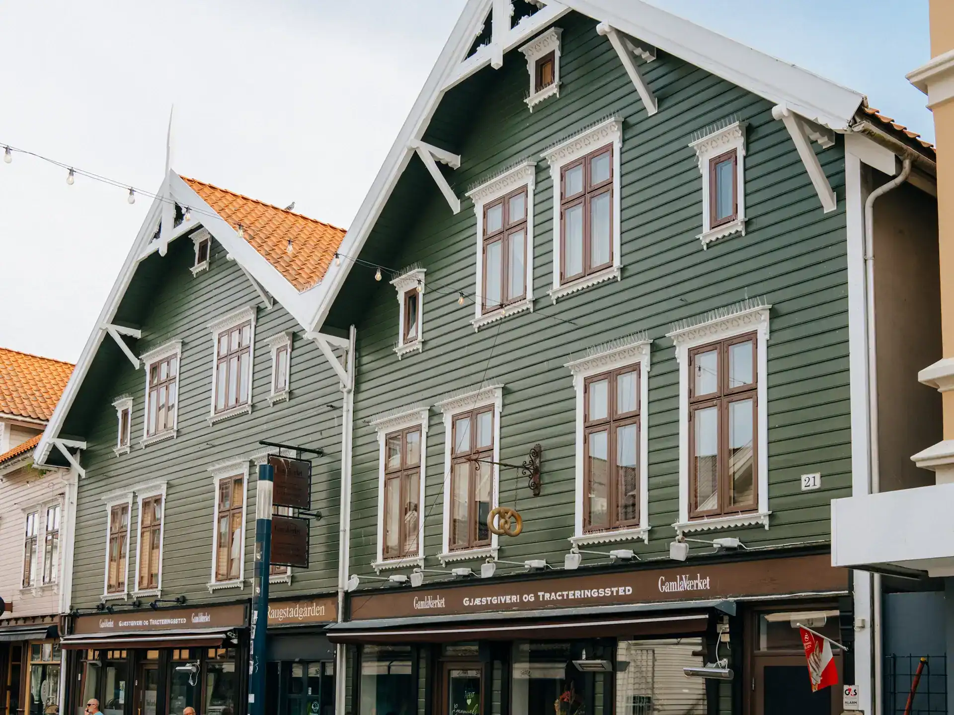 Historic green wooden building at Gamla Værket with traditional architecture and large windows.